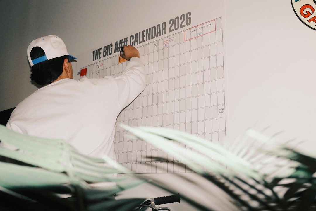 Woman marking renewal deadlines for vendor contracts on a wall calendar