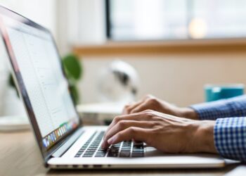 Marketer typing subject lines on a laptop before sending a campaign