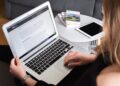 Propriétaire de petite entreprise comparant des constructeurs de pages sur un écran d'ordinateur portable