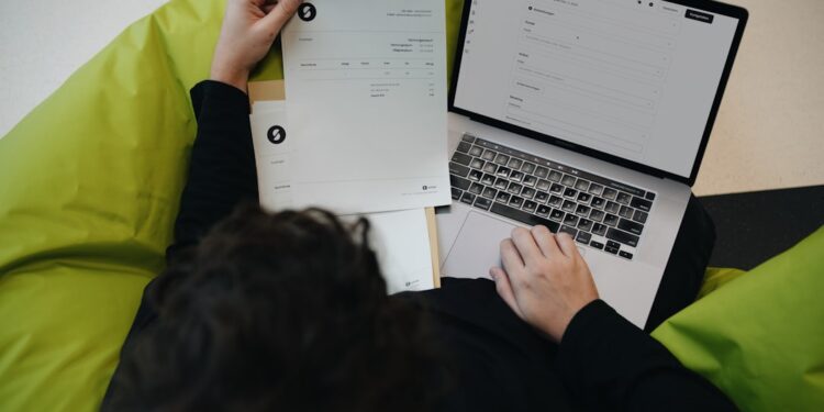 Service pricing: stop underselling yourself — photo 1 - STACKwebzine Freelancer calculating service pricing on a laptop