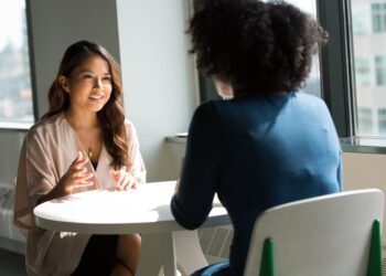 Two colleagues negotiating vendor contracts during an office meet