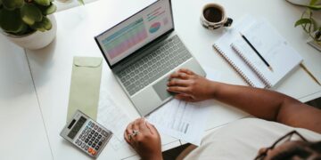 Financieel manager die een spreadsheet met Q4-budgetaanvragen controleert aan een bureau