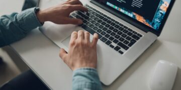 Password managers for teams real costs photo 1 - STACKwebzine IT administrator comparing password managers pricing on a laptop