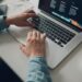Password managers for teams real costs photo 1 - STACKwebzine IT administrator comparing password managers pricing on a laptop